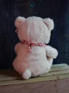 Мишка розовый в клетчатом слюнявчике 